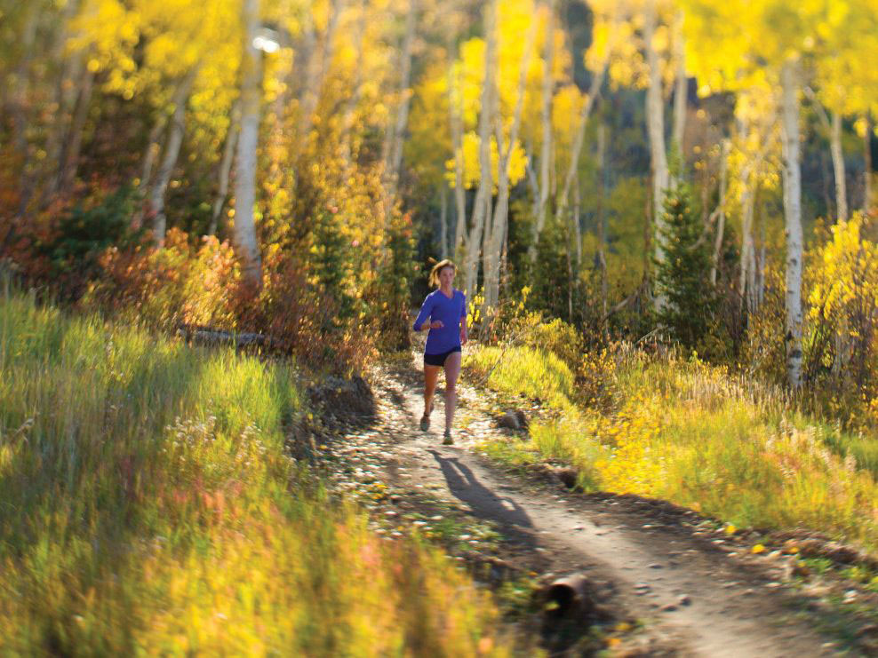 Woman running on a trail in the forest